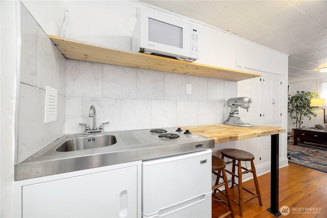902 Washington St, Wenatchee, WA 98801 - kitchen with white microwave, hardwood / wood-style flooring, wood counters, and white cabinetry