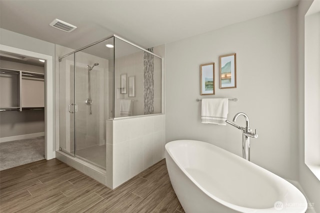 7176 Teal Loop, Gig Harbor, WA 98335 - bathroom with a shower stall, a soaking tub, a spacious closet, and wood finished floors