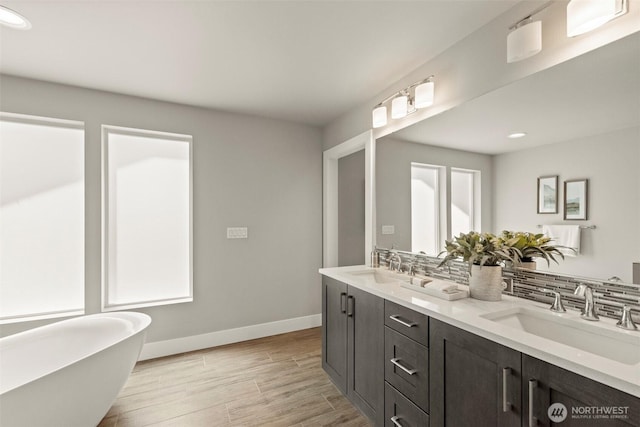 7176 Teal Loop, Gig Harbor, WA 98335 - bathroom featuring double vanity, a freestanding tub, recessed lighting, wood finished floors, and backsplash