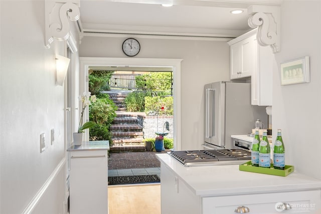 2707 4th Ave W, Seattle, WA 98119 - kitchen featuring stainless steel appliances, white cabinets, light countertops, and light wood-style flooring