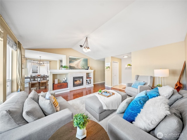 800 96th Ave NE Unit H202, Lake Stevens, WA 98258 - living room featuring a chandelier, wood finished floors, vaulted ceiling, and a tiled fireplace