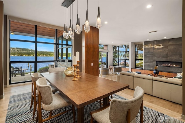 3840 E Mercer Way, Mercer Island, WA 98040 - dining room with a chandelier, a fireplace, light wood-type flooring, recessed lighting, and a water view