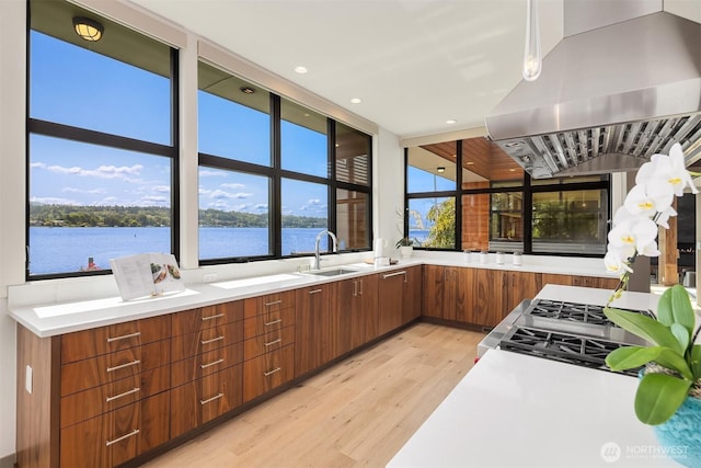 3840 E Mercer Way, Mercer Island, WA 98040 - kitchen featuring island exhaust hood, light wood-style floors, light countertops, modern cabinets, and brown cabinets