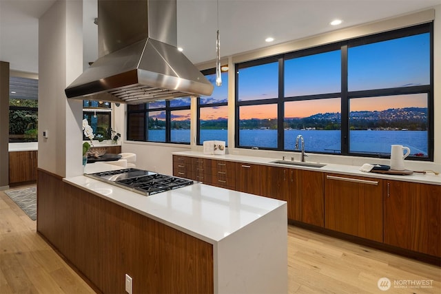 3840 E Mercer Way, Mercer Island, WA 98040 - kitchen featuring island exhaust hood, light wood-style flooring, stainless steel gas stovetop, light countertops, and modern cabinets