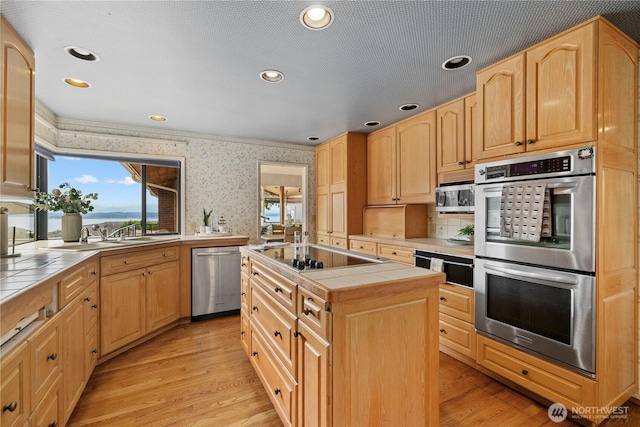 18035 8th Ave NW, Shoreline, WA 98177 - kitchen with appliances with stainless steel finishes, tile countertops, wallpapered walls, light brown cabinetry, and healthy amount of natural light