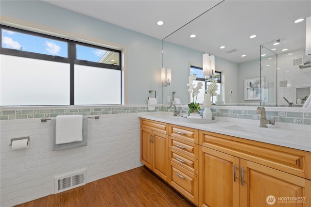 18035 8th Ave NW, Shoreline, WA 98177 - full bathroom with double vanity, an enclosed shower, tile walls, wood finished floors, and recessed lighting
