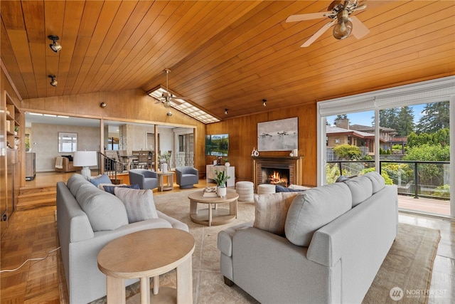 18035 8th Ave NW, Shoreline, WA 98177 - living room with a ceiling fan, lofted ceiling, a fireplace, wooden walls, and wood ceiling