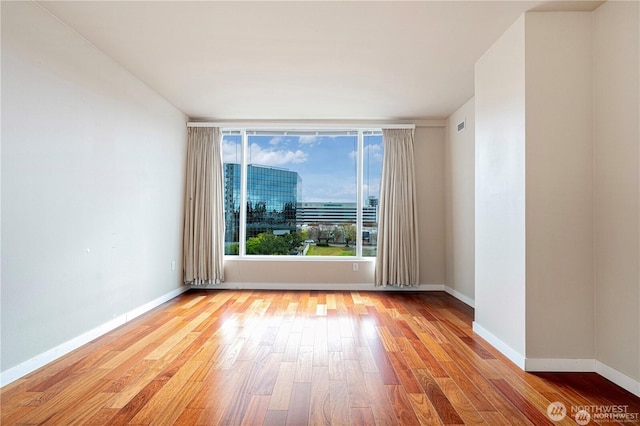 177 107th Ave NE Unit 1012, Bellevue, WA 98004 - unfurnished room with wood finished floors and baseboards