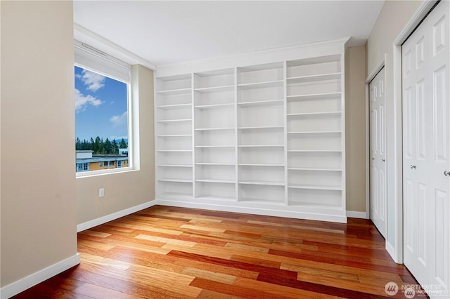 177 107th Ave NE Unit 1012, Bellevue, WA 98004 - unfurnished bedroom featuring wood finished floors and multiple closets