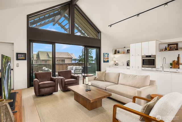 4566 Flying Goat Ave NE Unit C220, Bainbridge Island, WA 98110 - living room featuring light wood-style floors, high vaulted ceiling, and track lighting