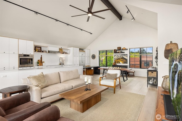 4566 Flying Goat Ave NE Unit C220, Bainbridge Island, WA 98110 - living room with beam ceiling, high vaulted ceiling, light wood finished floors, ceiling fan, and rail lighting