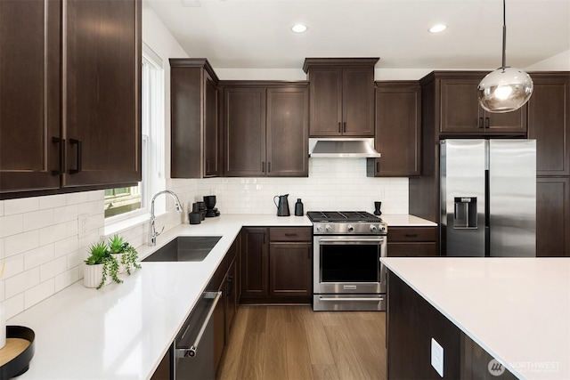 21822 25th Ave SE Unit B, Bothell, WA 98021 - kitchen featuring appliances with stainless steel finishes, exhaust hood, dark brown cabinetry, light countertops, and wood finished floors