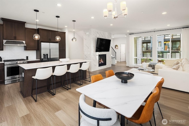21822 25th Ave SE Unit B, Bothell, WA 98021 - dining room featuring light wood finished floors, recessed lighting, a chandelier, and a fireplace