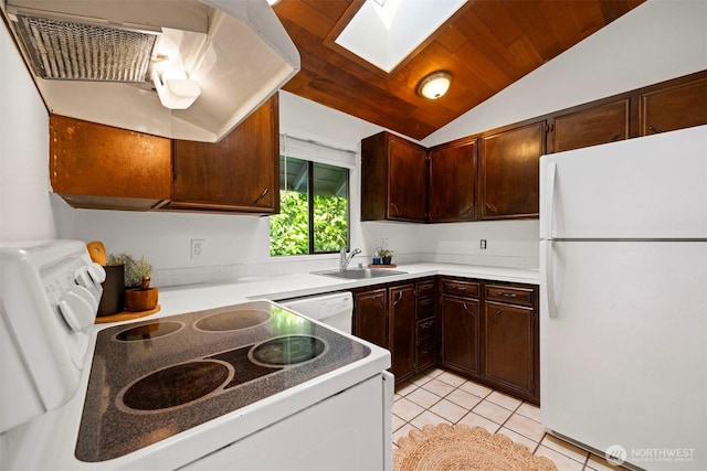 606 N State St, Bellingham, WA 98225 - kitchen featuring white appliances, vaulted ceiling, a skylight, light tile patterned floors, and extractor fan