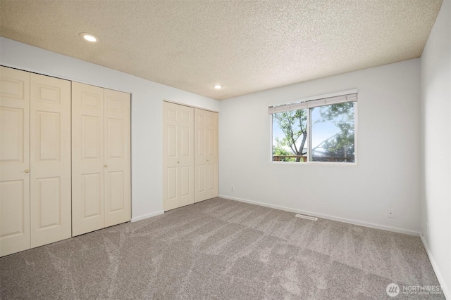 606 N State St, Bellingham, WA 98225 - unfurnished bedroom with two closets, carpet flooring, a textured ceiling, and recessed lighting