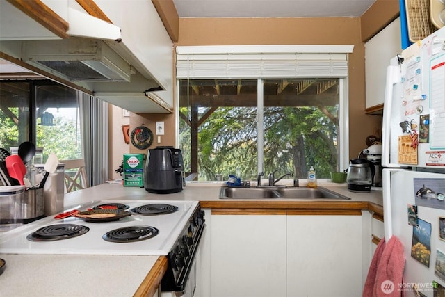 606 N State St, Bellingham, WA 98225 - kitchen featuring freestanding refrigerator, light countertops, white cabinetry, electric range, and plenty of natural light