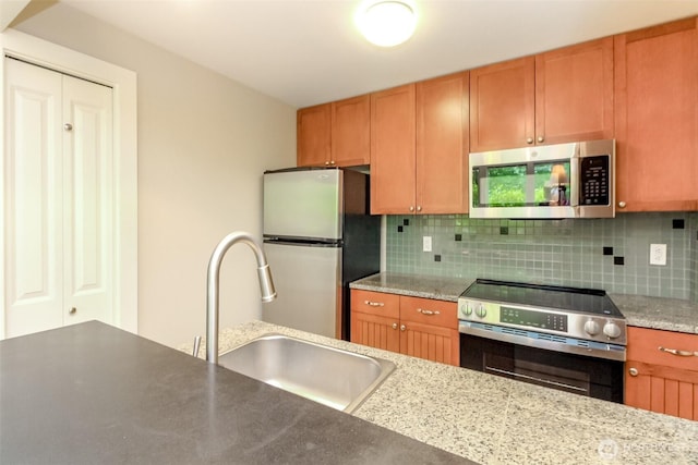 3008 N Narrows Dr Unit B102, Tacoma, WA 98407 - kitchen featuring appliances with stainless steel finishes, backsplash, and brown cabinets