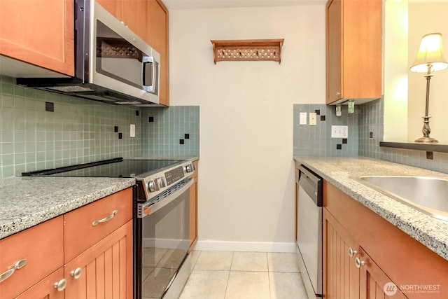 3008 N Narrows Dr Unit B102, Tacoma, WA 98407 - kitchen with stainless steel appliances, tasteful backsplash, light tile patterned floors, and light stone countertops
