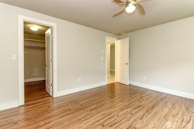 3008 N Narrows Dr Unit B102, Tacoma, WA 98407 - unfurnished bedroom featuring light wood-style flooring, a walk in closet, and a ceiling fan
