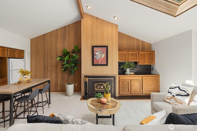 5665 E Mercer Way, Mercer Island, WA 98040 - living area with wood walls, high vaulted ceiling, light colored carpet, and a fireplace with flush hearth