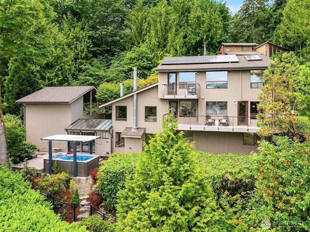5665 E Mercer Way, Mercer Island, WA 98040 - back of house with a balcony, solar panels, and roof with shingles