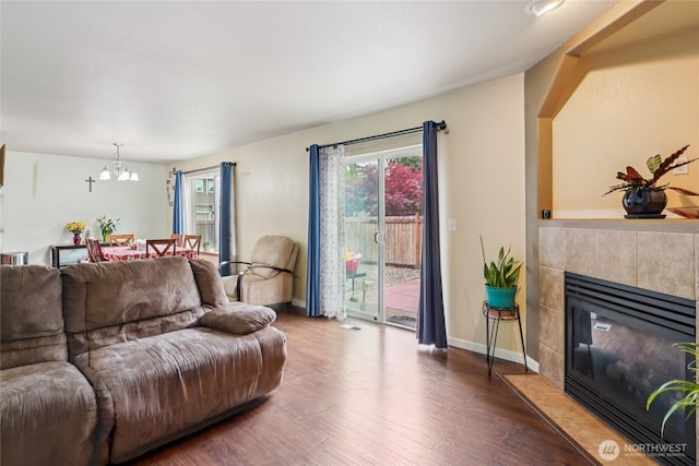 17707 1st Avenue Ct E, Spanaway, WA 98387 - living room with a chandelier, dark wood-style flooring, and a tiled fireplace