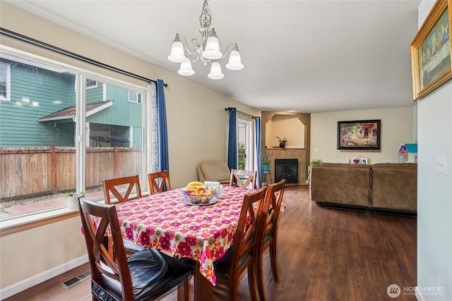 17707 1st Avenue Ct E, Spanaway, WA 98387 - dining area featuring a chandelier, wood finished floors, and a tiled fireplace