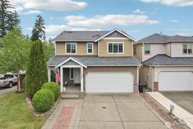 17707 1st Avenue Ct E, Spanaway, WA 98387 - view of front facade featuring concrete driveway, a porch, an attached garage, and brick siding