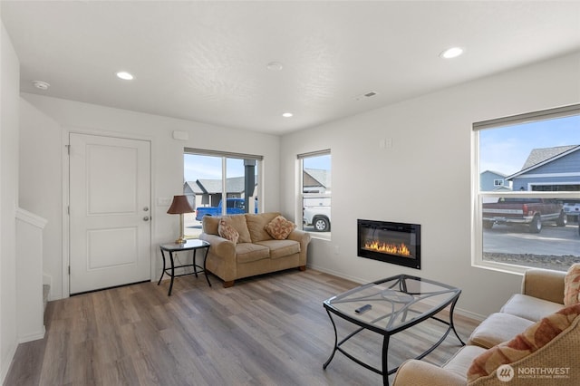 928 N Washington Ct, Moses Lake, WA 98837 - living room featuring wood finished floors, a glass covered fireplace, and recessed lighting
