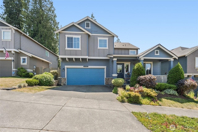 26707 NE 144th Ct, Duvall, WA 98019 - craftsman house featuring board and batten siding, stone siding, an attached garage, driveway, and covered porch
