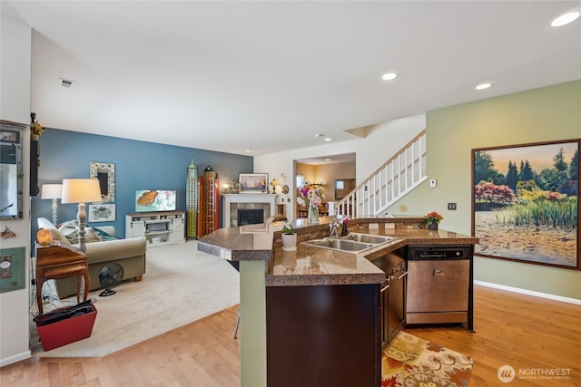26707 NE 144th Ct, Duvall, WA 98019 - kitchen with dishwasher, a tiled fireplace, light wood finished floors, tile countertops, and a kitchen island with sink
