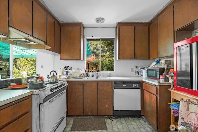 1412 N 40th St, Renton, WA 98056 - kitchen with white appliances, light floors, under cabinet range hood, light countertops, and brown cabinetry