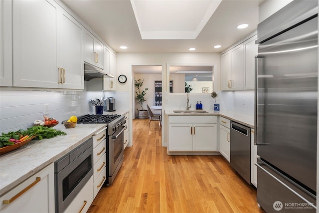 4662 95th Ave NE, Yarrow Point, WA 98004 - kitchen with premium appliances, under cabinet range hood, decorative backsplash, white cabinets, and recessed lighting