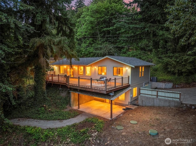4120 Lake House Ln SE, Olympia, WA 98513 - back of house with a forest view, a wooden deck, a shingled roof, and a carport