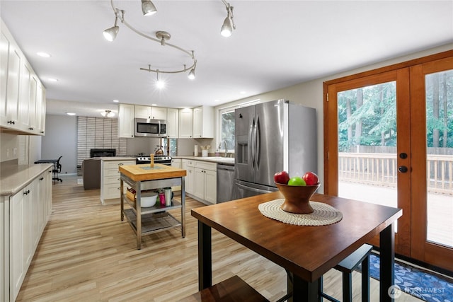 8200 NE View Ridge Ln, Poulsbo, WA 98370 - kitchen featuring stainless steel appliances, a fireplace, plenty of natural light, white cabinets, and recessed lighting