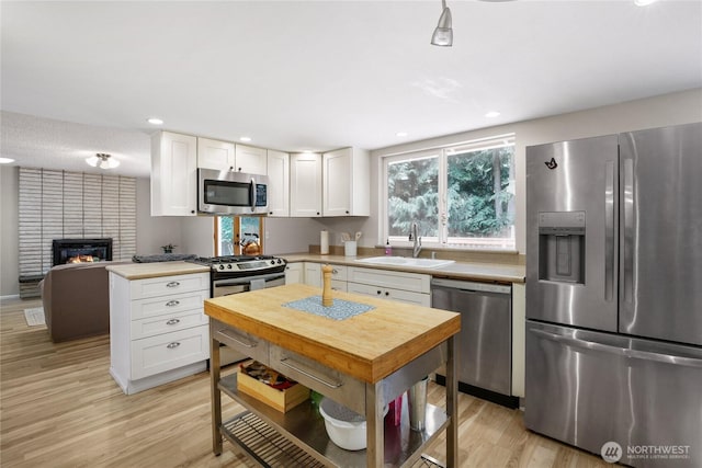 8200 NE View Ridge Ln, Poulsbo, WA 98370 - kitchen featuring stainless steel appliances, white cabinets, light wood finished floors, light countertops, and recessed lighting