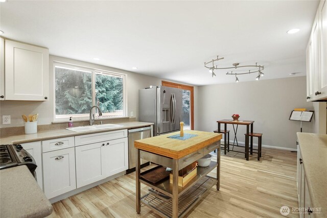 8200 NE View Ridge Ln, Poulsbo, WA 98370 - kitchen featuring stainless steel appliances, light wood finished floors, white cabinets, light countertops, and recessed lighting