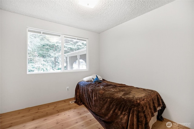 8200 NE View Ridge Ln, Poulsbo, WA 98370 - bedroom featuring a textured ceiling and light wood-style flooring