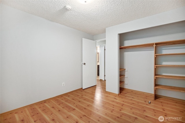 8200 NE View Ridge Ln, Poulsbo, WA 98370 - unfurnished bedroom with wood finished floors, a textured ceiling, and a closet