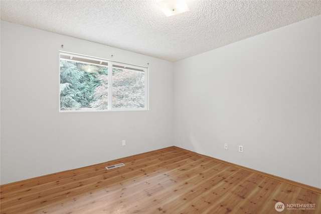 8200 NE View Ridge Ln, Poulsbo, WA 98370 - spare room featuring wood finished floors and a textured ceiling