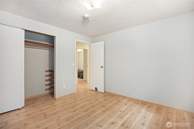 8200 NE View Ridge Ln, Poulsbo, WA 98370 - unfurnished bedroom featuring wood finished floors, a textured ceiling, and a closet