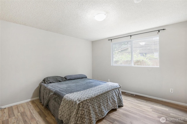 8200 NE View Ridge Ln, Poulsbo, WA 98370 - bedroom featuring a textured ceiling and wood finished floors