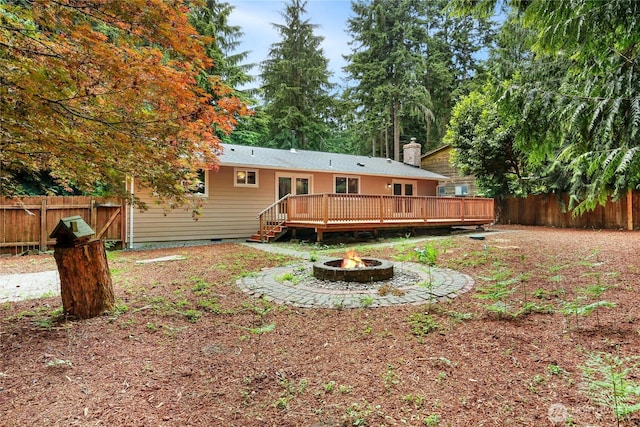 8200 NE View Ridge Ln, Poulsbo, WA 98370 - back of house with an outdoor fire pit, a deck, a fenced backyard, crawl space, and a chimney