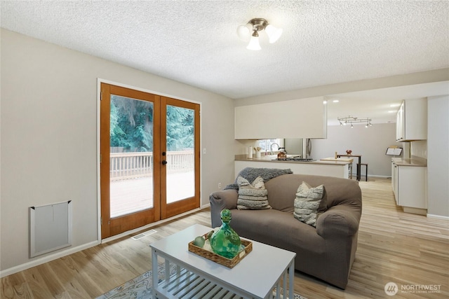 8200 NE View Ridge Ln, Poulsbo, WA 98370 - living area with french doors, light wood-type flooring, and a textured ceiling