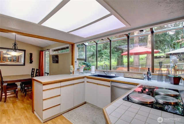 908 185th St SW, Lynnwood, WA 98037 - kitchen featuring a peninsula, lofted ceiling, pendant lighting, stainless steel dishwasher, and light wood-style flooring