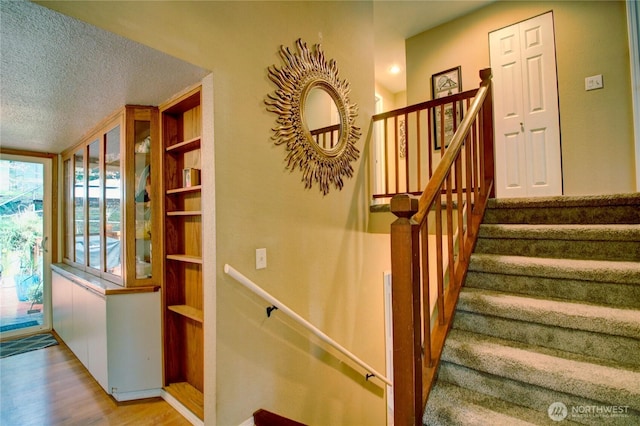 908 185th St SW, Lynnwood, WA 98037 - stairway featuring a textured ceiling and wood finished floors