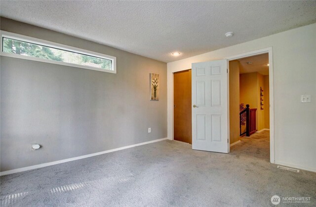 908 185th St SW, Lynnwood, WA 98037 - unfurnished bedroom featuring carpet flooring and a textured ceiling