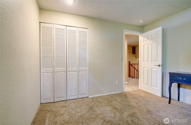908 185th St SW, Lynnwood, WA 98037 - unfurnished bedroom featuring carpet flooring, a textured ceiling, a closet, and a textured wall