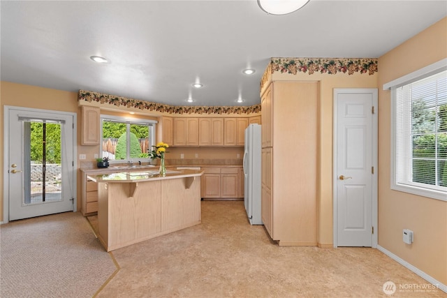 840 Amy Ct, East Wenatchee, WA 98802 - kitchen featuring freestanding refrigerator, light brown cabinets, a kitchen breakfast bar, light countertops, and healthy amount of natural light