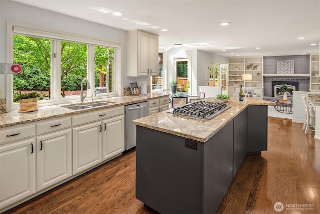 2778 142nd Pl NE, Bellevue, WA 98007 - kitchen with stainless steel appliances, dark wood-type flooring, a fireplace, light stone counters, and a center island